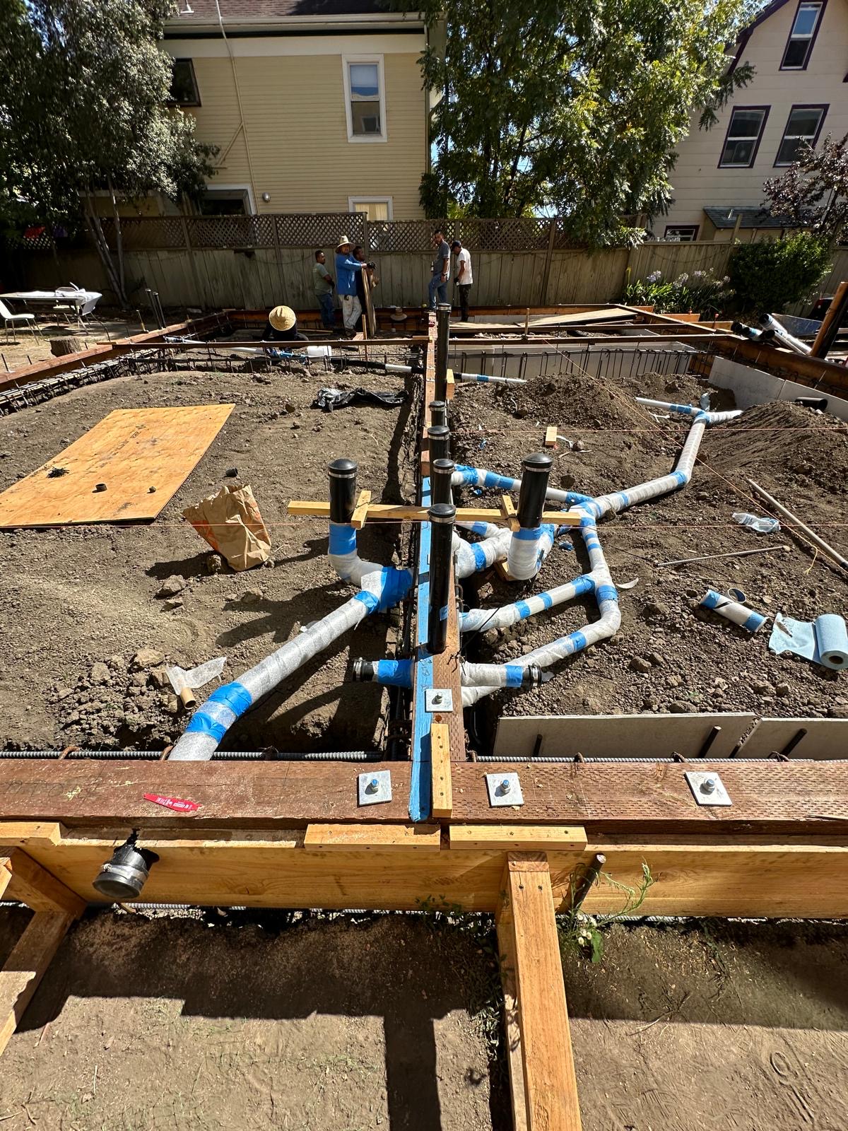 Under-slab drain waste and vent manifold set inside foundation forms