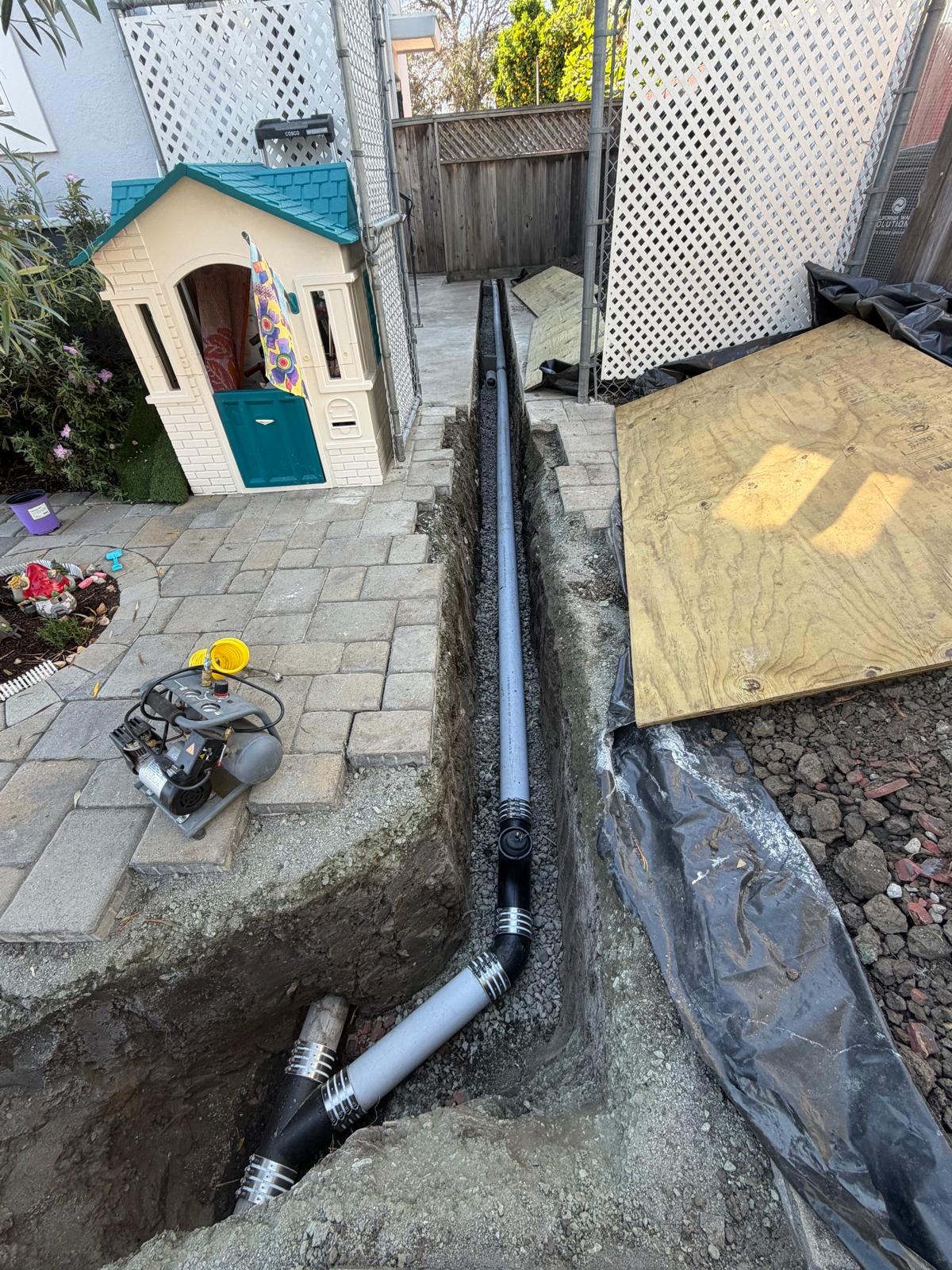 New sewer lateral installed in a trench across a backyard